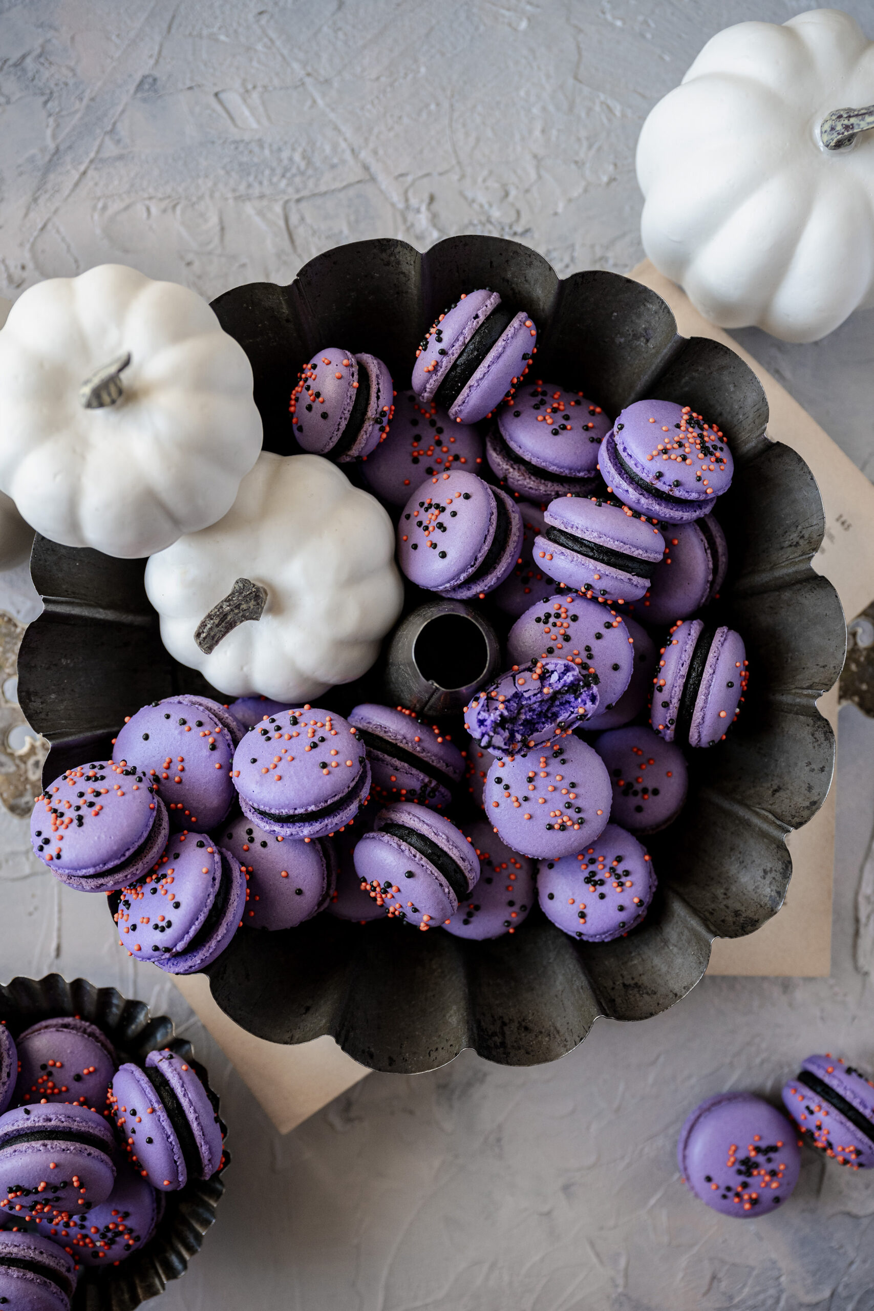 Deep purple and black macaroons with white mini pumpkins set the scene for a festive Halloween, whether your guests are children or adults!